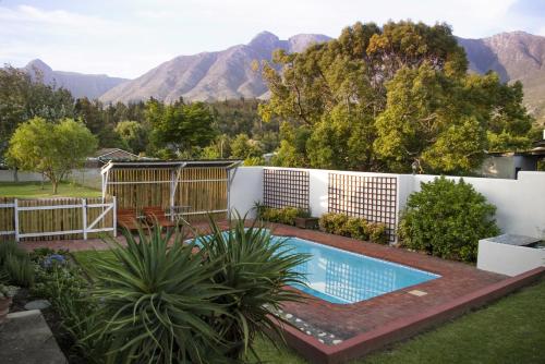 a swimming pool in a yard with mountains in the background at 33 Berg Selfcatering in Swellendam