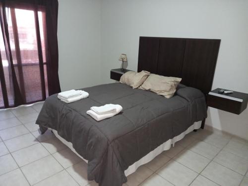 a bedroom with a bed with two towels on it at Nueva Era Apart in La Consulta
