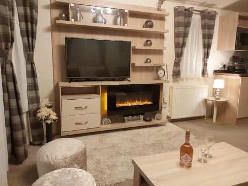 a living room with a television and a fireplace at 180 Golden Gate North Wales in Abergele