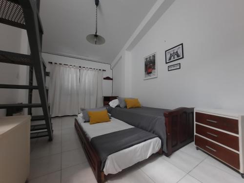 Un dormitorio con 2 camas y una escalera. en Departamento Coronel Arias en San Salvador de Jujuy
