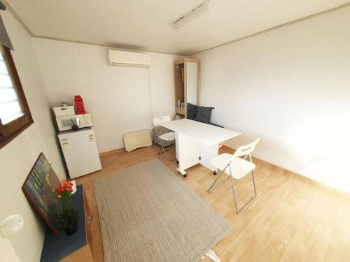 een woonkamer met een witte tafel en stoelen bij Private House Isu in Seoul