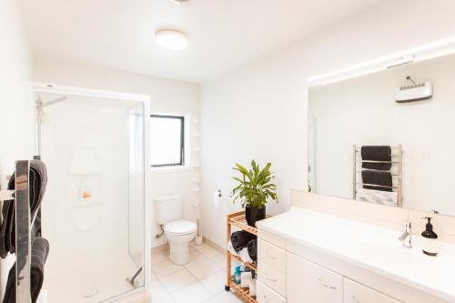 bagno con lavandino, servizi igienici e specchio di Sunrise on Main a Tairua