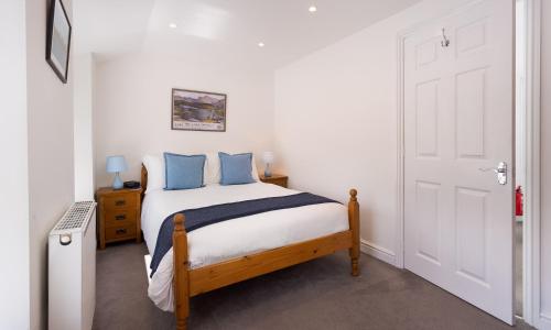 a bedroom with a bed with blue pillows at Fern Cottage in Ambleside