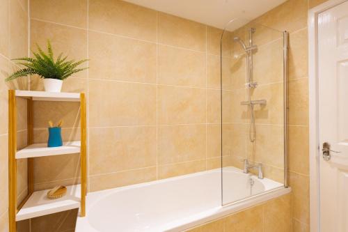 a bathroom with a shower and a bath tub with a shower at Fern Cottage in Ambleside