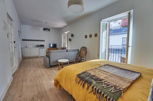 a bedroom with a bed and a living room at Casa Pureza in Seville