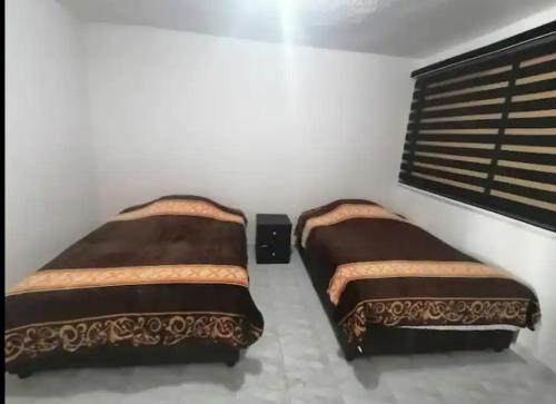 een slaapkamer met 2 bedden en een raam bij Hogar amplio y acogedor in Ixmiquilpan