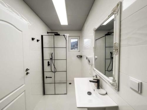 La salle de bains blanche est pourvue d'un lavabo et d'un miroir. dans l'établissement Diamond Villas, à Enina