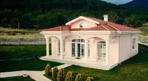 une petite maison blanche avec un toit rouge dans l'établissement Diamond Villas, à Enina