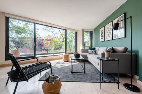a living room with a couch and a large window at The Corner Condesa in Mexico City