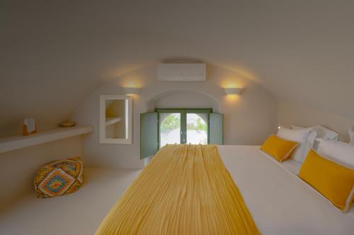 a bedroom with a large bed and a window at Elements Cave Suites in Megalokhori