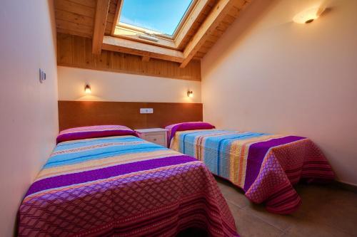 two beds in a room with a window at Hostal Parque Natural in Benasque