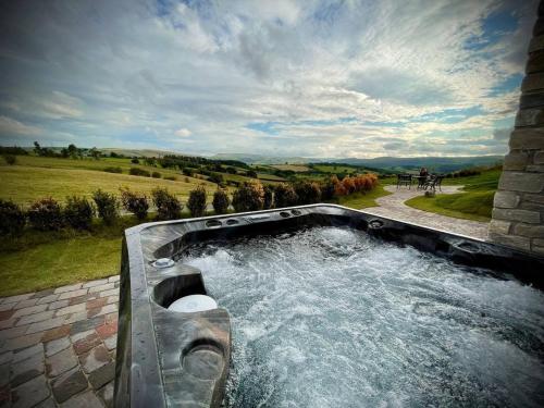 a hot tub with water in it in a field at Rabbits View in Rhayader