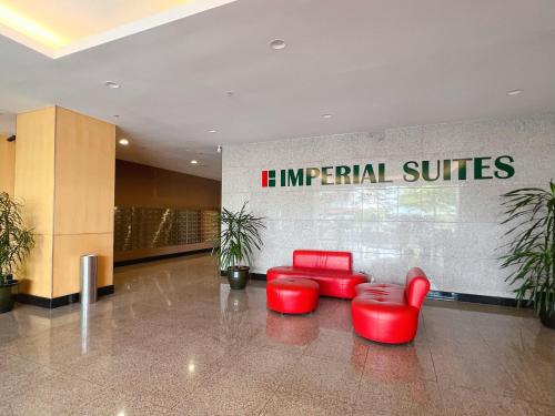 a lobby with two red chairs and a sign that reads imperial suites at Imperial Grand Suite Apartment Kuching in Kuching