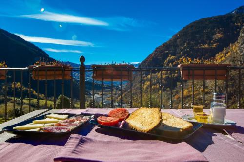 a table with a tray of bread and other food at Hostal Parque Natural in Benasque