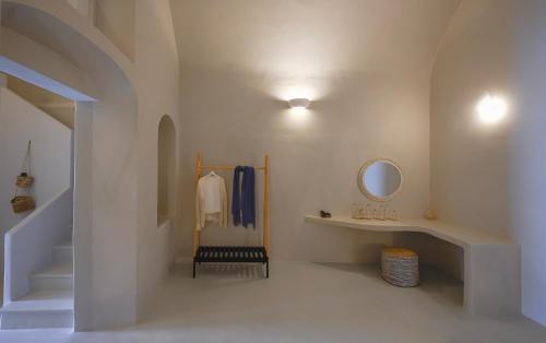 a hallway with a staircase with a mirror and a sink at Elements Cave Suites in Megalochori