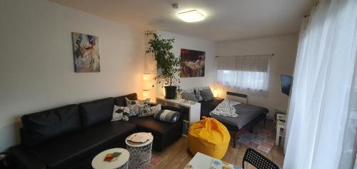 a living room with a black couch and a table at Apartmány Tylovice in Rožnov pod Radhoštěm