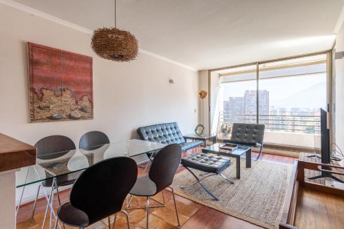 a living room with a glass table and chairs at Century View 2B W/Balcony, View & Parking. in Santiago