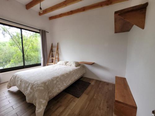 a bedroom with a bed and a large window at Cabañas Llifenativo in Futrono