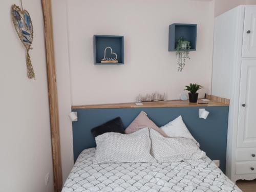 um quarto com uma cama com uma cabeceira azul em REL'AX - T2 - Plein coeur Ax - Literie de qualité - Wifi - 200m télécabine em Ax-les-Thermes