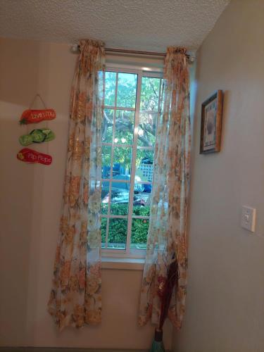 a window with curtains in a room at ROSI Ocean Sand Hotel Apt (@Sandcastles) in Ocho Rios