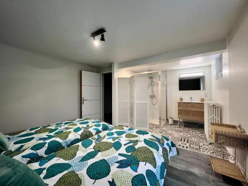 een slaapkamer met een bed met een blauw en wit dekbed bij Charmante Villa Quintel - Proche Gare & Centre in Brive-la-Gaillarde
