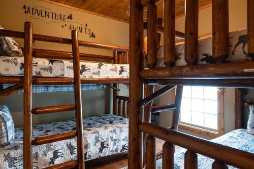 a room with three bunk beds in a cabin at stayNantahala - Smoky Mountain Cabins in Aquone