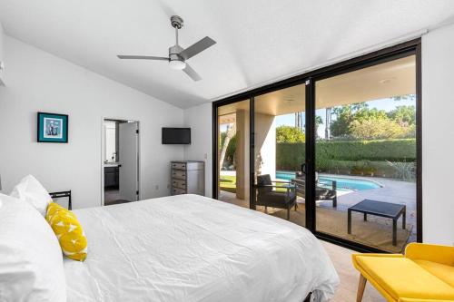 ein Schlafzimmer mit einem weißen Bett und einer Glasschiebetür in der Unterkunft The Sunset House Pool & Spa in Palm Springs