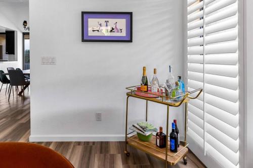 a room with a shelf with bottles on a wall at The Sunset House Pool & Spa in Palm Springs