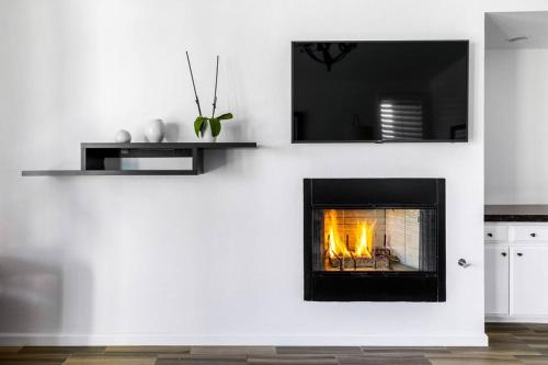 a living room with a fireplace in a white wall at The Sunset House Pool & Spa in Palm Springs