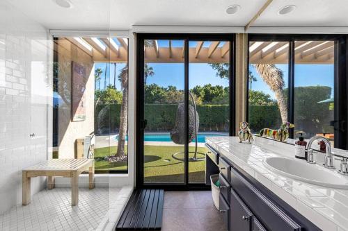 a bathroom with a sink and a view of a pool at The Sunset House Pool & Spa in Palm Springs