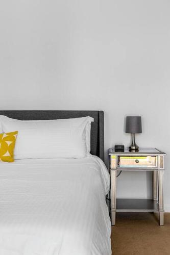 a bed with a side table with a lamp on it at The Sunset House Pool & Spa in Palm Springs