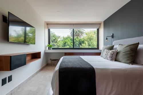 a bedroom with a large bed and a large window at The Corner Condesa in Mexico City