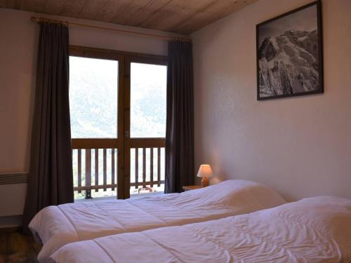 une chambre avec deux lits et une grande fenêtre dans l'établissement Appartement 2 pièces avec balcon, animaux admis - Méribel - FR-1-180-83, à Méribel