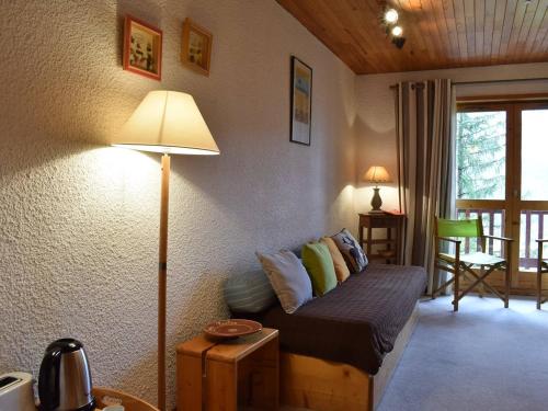 - un salon avec un lit et une lampe dans l'établissement Charmant 2 pièces à Méribel, proche pistes et commerces, parking inclus - FR-1-180-88, à Méribel