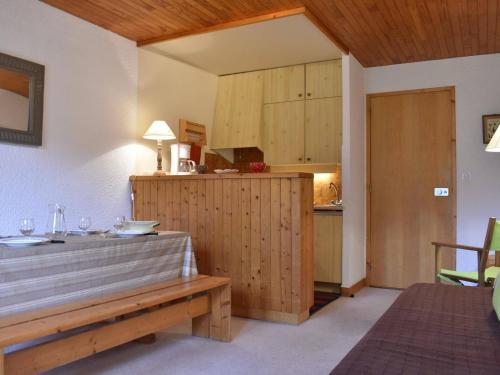 une cuisine avec des placards en bois et un banc en bois dans l'établissement Charmant 2 pièces à Méribel, proche pistes et commerces, parking inclus - FR-1-180-88, à Méribel