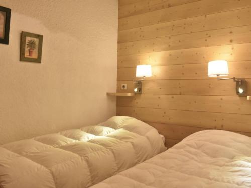 - 2 lits dans une chambre avec 2 lumières sur le mur dans l'établissement Méribel: Charmant 2P, 4 Pers, proche commerces et pistes - FR-1-180-80, à Méribel