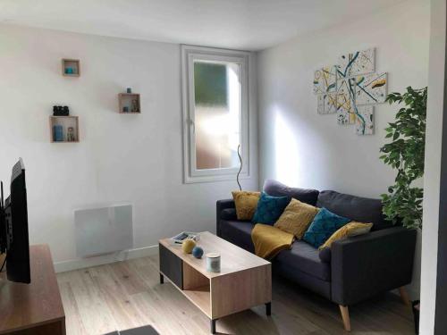 a living room with a blue couch and a table at Appartement duplex : Le Cosy in Montgeron