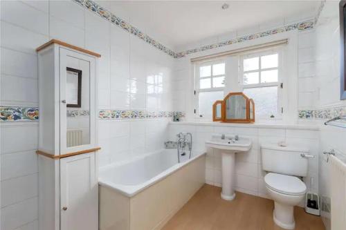 a bathroom with a tub and a toilet and a sink at Superb 5 bedroom Villa 16 mins from City Centre in Musselburgh