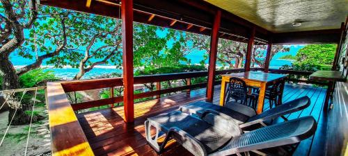 a balcony of a house with a table and chairs at MOOREA - The Golden Reef Bungalow Bora Bora in Temae