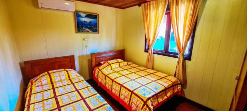 - une chambre avec 2 lits et une fenêtre dans l'établissement MOOREA - The Golden Reef Bungalow Bora Bora, à Temae
