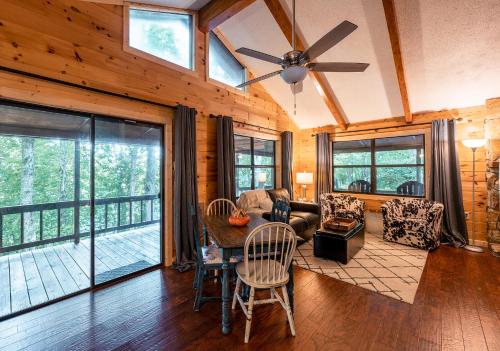a living room with a ceiling fan and a couch at stayNantahala - Smoky Mountain Cabins in Aquone