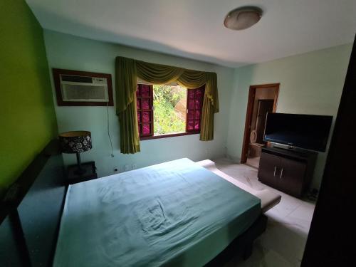 ein Schlafzimmer mit einem großen Bett und einem Fenster in der Unterkunft Aconchego da Serra in Teresópolis