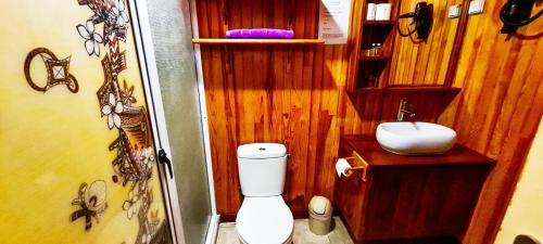 uma casa de banho com um WC branco e um lavatório. em MOOREA - The Golden Reef Bungalow Moorea em Temae