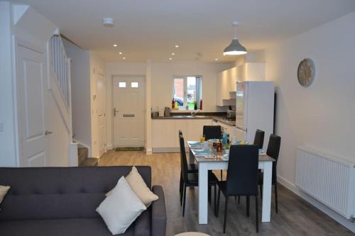 a living room and kitchen with a table and chairs at Erasmus House - 3 Bedrooms - City Centre, Netflix, WIFI, Free Private Parking in Derby