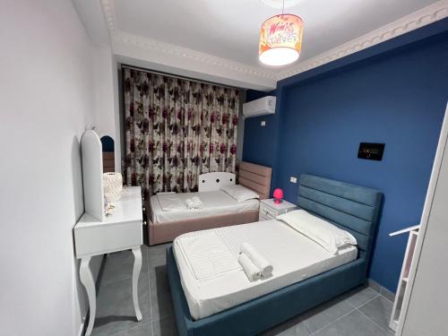 Habitación con 2 camas y pared azul en Apartment rent Elbasan city center 1 en Elbasan