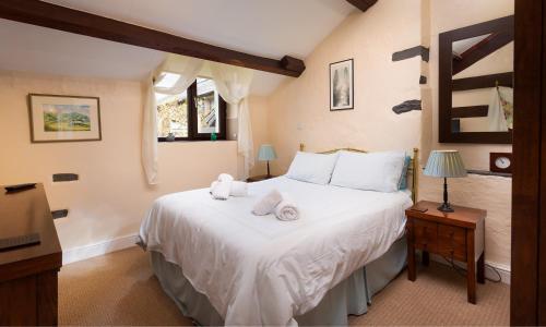 a bedroom with a large white bed with towels on it at Old Coach House in Ambleside