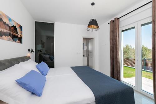 a bedroom with a bed and a large window at Villa Mateo 2 in Ližnjan