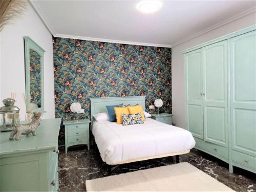 a bedroom with a bed with blue cabinets and a wallpaper at Piso-Loft COS Centro Jaén 2 in Jaén