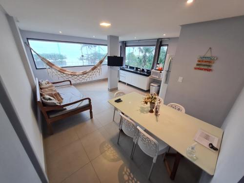 a kitchen and dining room with a table and chairs at Apt FRENTE MAR MEAIPE COMPLETO in Guarapari