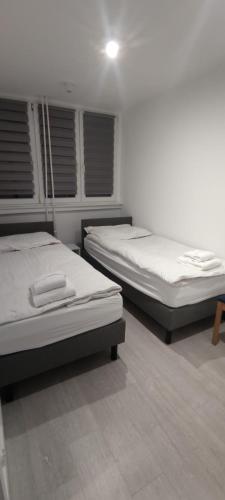 two twin beds in a room with at Apartament Miedzianka III in Polkowice